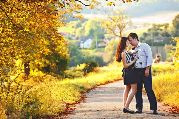 Casal jovem fica no caminho no parque de outono — Fotografia de Stock