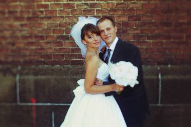 Damat onu eski bir tuğla hugs iken gelin peçe Rüzgar esiyor