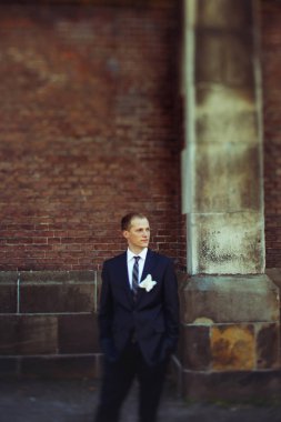 Damat uzaktan bir Katedrali arkasında dururken görünüyor. 