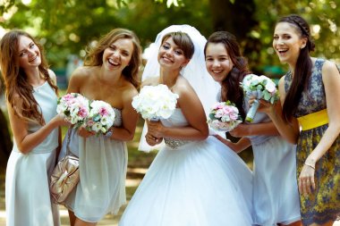 Gelin pozlar bouqets ile mutlu nedime ile gülümseyen onların