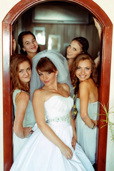 Bruid poses in deuren omringd door mooie bruidsmeisjes — Stockfoto