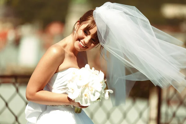 Nevěsta vypadá šťastně, těší vítr na střeše — Stock fotografie