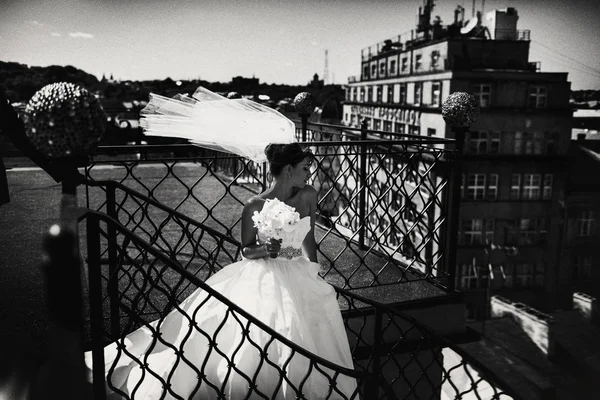 La mariée pose sur les escaliers en colimaçon sur le toit par temps venteux — Photo