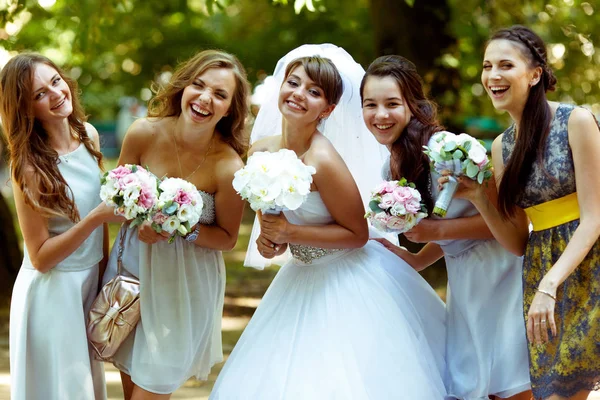 Gelin pozlar bouqets ile mutlu nedime ile gülümseyen onların