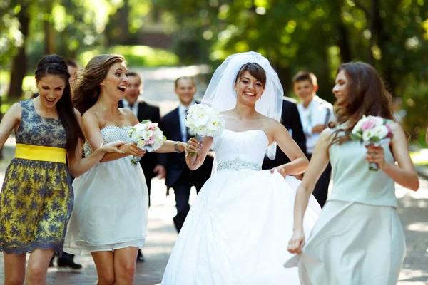 Demoiselles d'honneur ont du plaisir tout en se promenant avec la mariée dans le parc — Photo