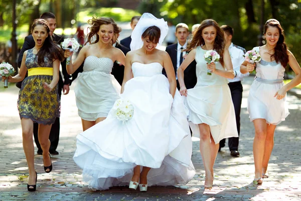 Ładna Panna Młoda trzyma jej sukienkę i chodzić z dziewczynami wzdłuż pa — Zdjęcie stockowe