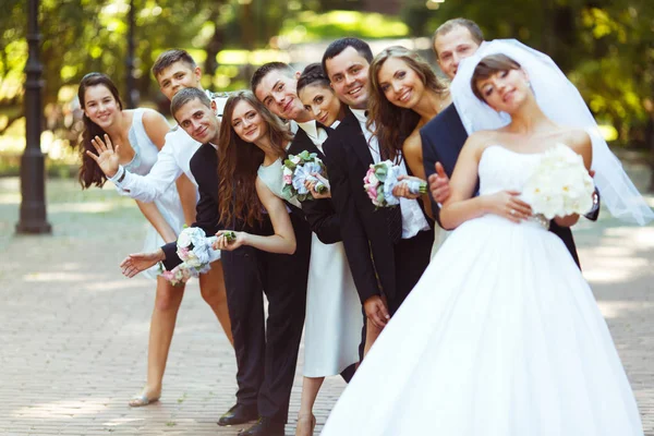 Noiva, noivo e amigos ficar no raio enquanto posando no pa — Fotografia de Stock