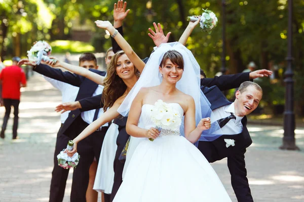 Marié et amis se tiennent dans le rayon derrière une mariée dansant dans le — Photo