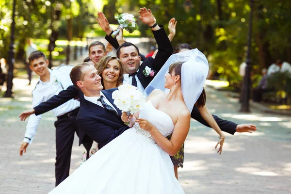 Bride looks over shoulder on friends while they hide behind her — Stock Photo, Image