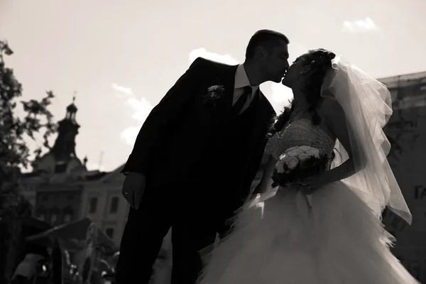 Una foto en blanco y negro del novio inclinándose a la novia para besarla — Foto de Stock