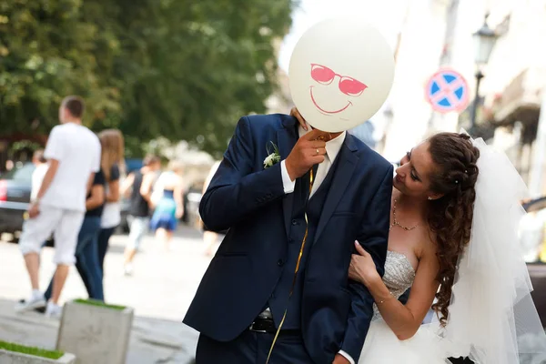 Жених веселится, прячась за улыбающимся воздушным шаром — стоковое фото