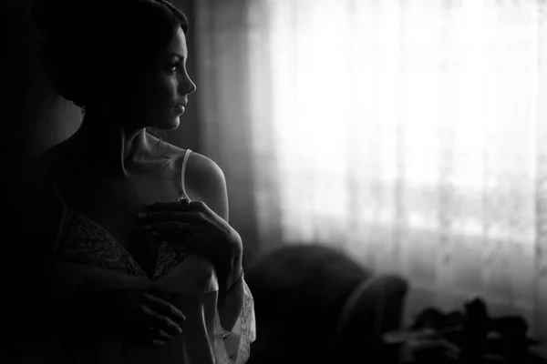 The tenderness bride stands near window — Stock Photo, Image