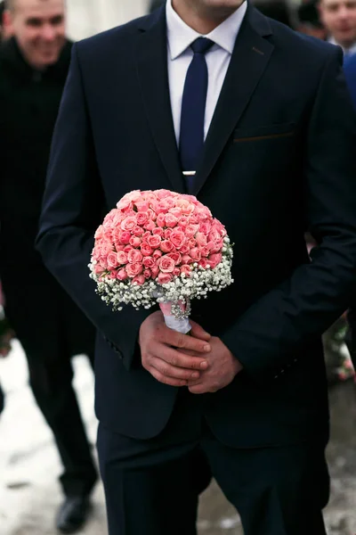 De bruidegom houdt boeket voor bruid — Stockfoto