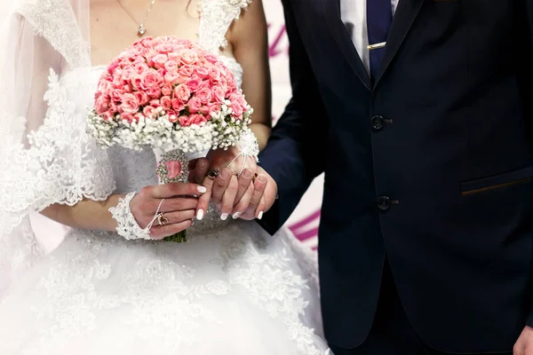 De bruiden houden handen in de buurt van bruiloft banner — Stockfoto