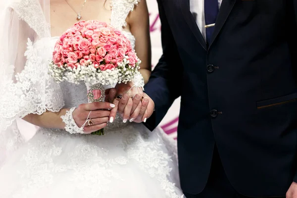 Las novias se toman de la mano cerca de la bandera de boda — Foto de Stock