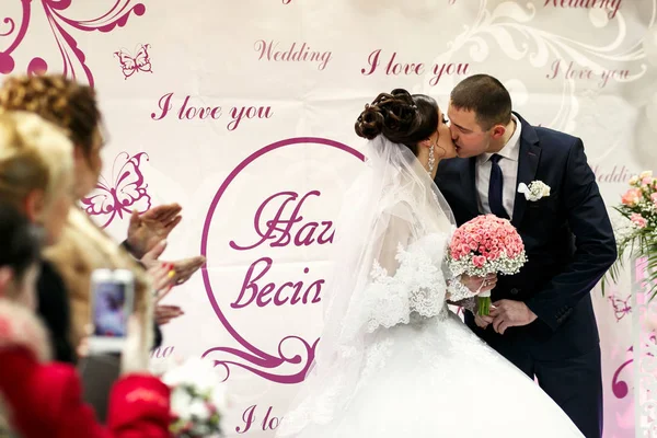 As noivas se beijando perto do banner do casamento — Fotografia de Stock