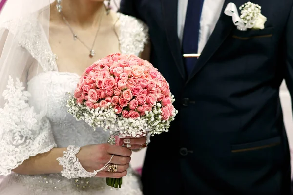 Brudar håller händerna nära bröllop banner — Stockfoto