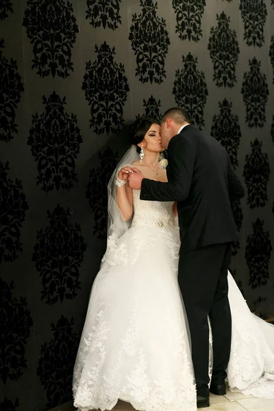 O lindo casal apaixonado beijando perto da parede — Fotografia de Stock