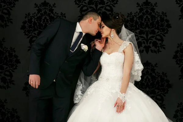 Le beau couple amoureux s'embrassant près du mur — Photo
