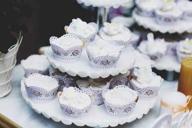 Beyaz sır ile kaplı cupcakes yorgun çanak üzerinde durmak