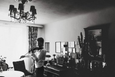 Adam bir pencere önünde bekleyen bir keman çalış 