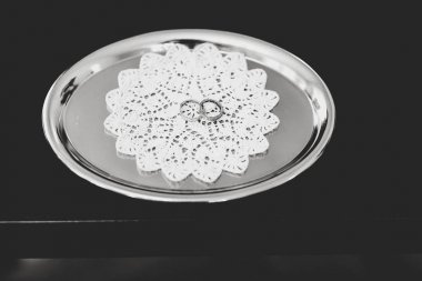 Çelik tepsi üzerinde beyaz bir peçete üzerinde hassas Gümüş Alyanslar yalan