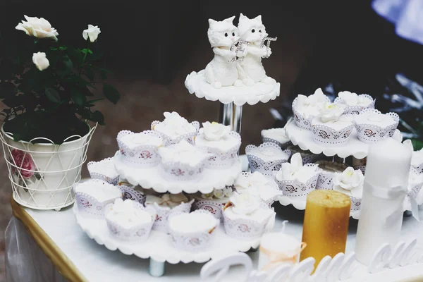 Mooie witte cupcakes staan op laden op een tafel — Stockfoto