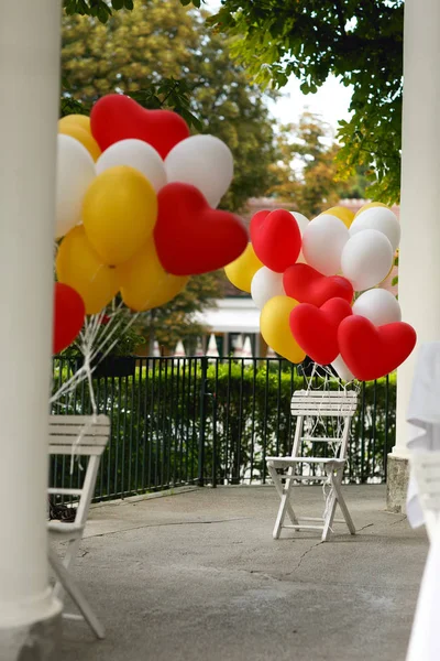 Yellow, red and white balloons with a heart shape pinned to the