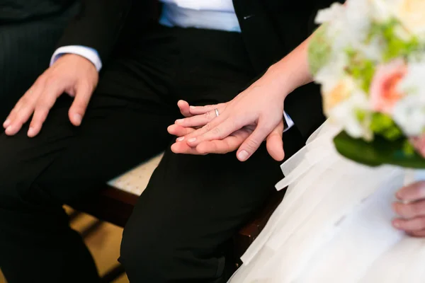 La main tendre de la mariée avec une alliance repose sur le genou du marié — Photo