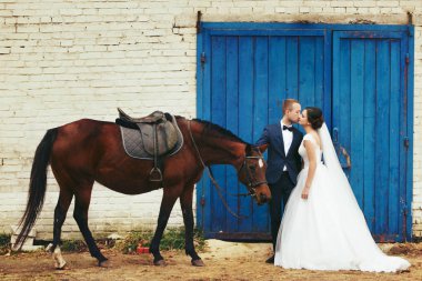 Gelin ve damat mavi kapıları arkasında bir at ile stand 