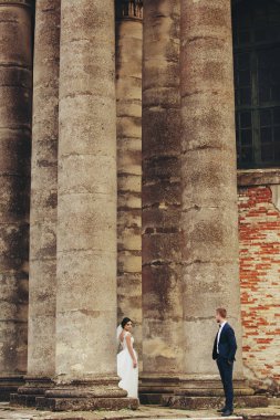 Sütunlar arasında duran gelin damat bakar 