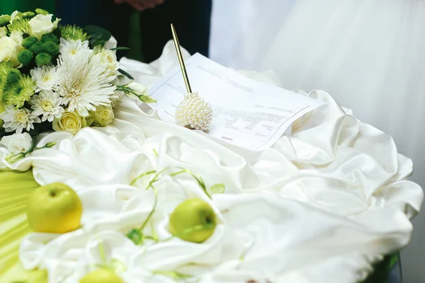 Документы о помолвке лежат на белом столе, украшенном яблоком — стоковое фото
