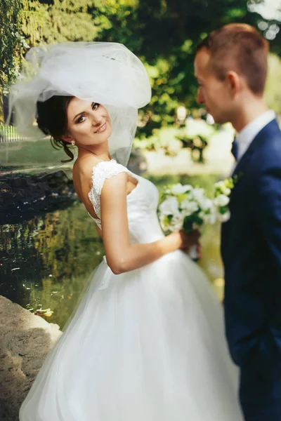 Menyasszonyi fátyol repül a feje fölött, míg ő áll a tavon sh — Stock Fotó