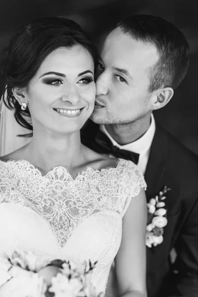 Sposo baci sposa guancia abbracciarla da dietro — Foto Stock
