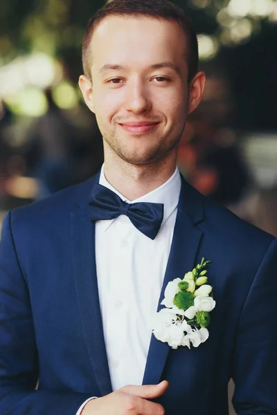 Un retrato de un novio en traje azul con boutonni verde y blanco — Foto de Stock