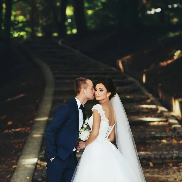 Sposo raggiunge la guancia sposa mentre lei sta con ey chiuso — Foto Stock