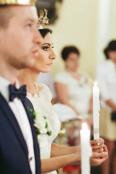 Braut schaut ernst und hält Kerze im Arm — Stockfoto