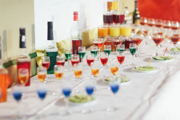 Different colored shots stand on the table with alcohol — Stock Photo, Image