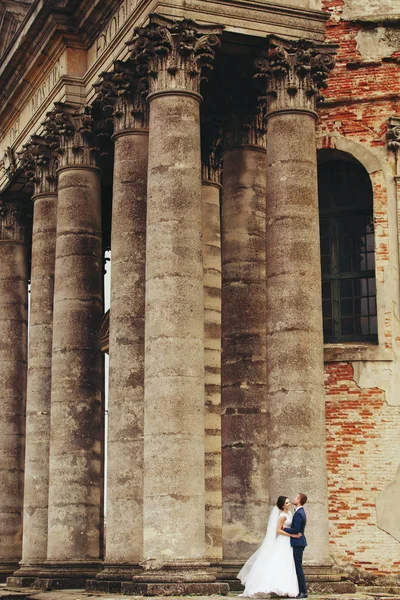 Casamento casal fica na frente de uma velha catedral — Fotografia de Stock