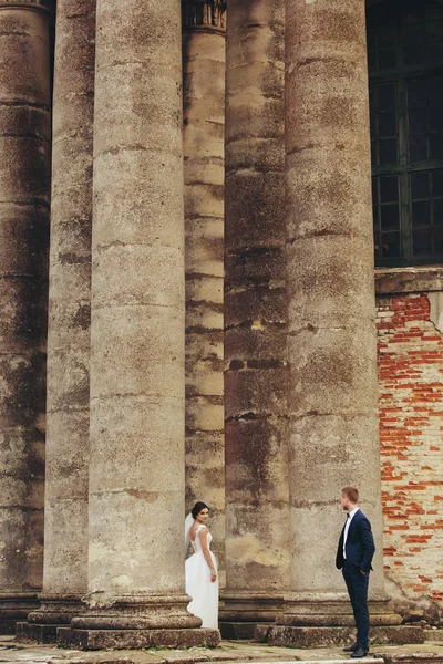 Sütunlar arasında duran gelin damat bakar 