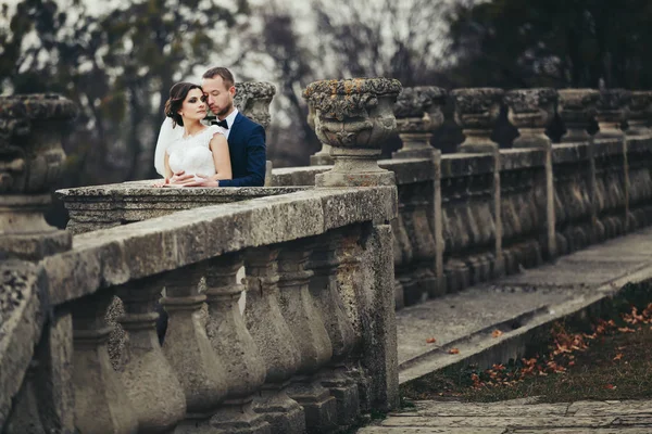 Vőlegény hajlik a menyasszony mögött egy félig romos erkély — Stock Fotó