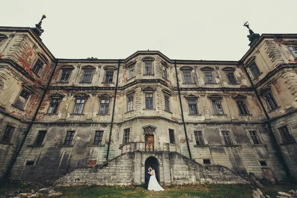 新娘和新郎构成背后，在古老的城堡的入口处 — 图库照片