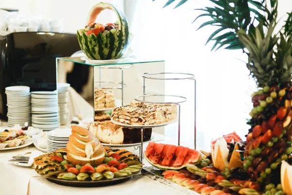 Fruits et pâtisseries sur le buffet derrière la vaisselle vide — Photo