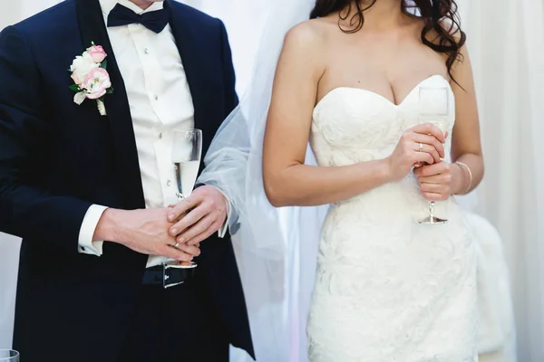 Para ślub przytrzymaj okulary z szampanem w swoich ramionach — Zdjęcie stockowe