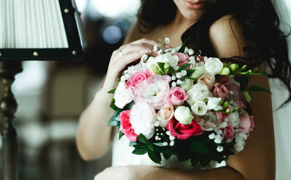 Нежная невеста прикасается к розовому свадебному букету, стоящему в домике — стоковое фото