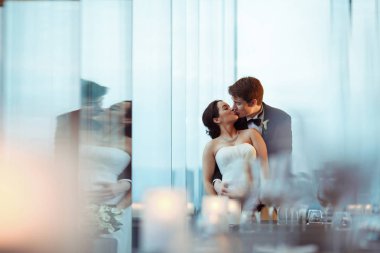 Onu arkadan bir cam sarılma bir esmer gelin damat kisses