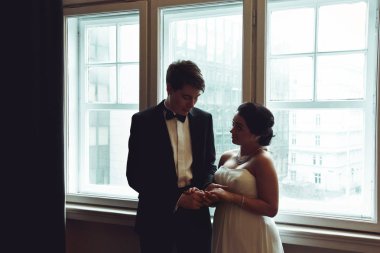 Damat gelinin el ile ona göz önünde ayakta hayran bir 