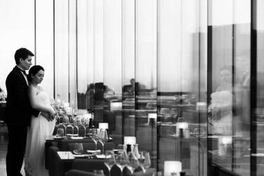 Nişanlısı ile pa duran bir hamile gelin arkasından sarılarak