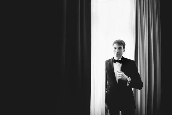 Une image en noir et blanc de beau marié debout derrière un wi — Photo