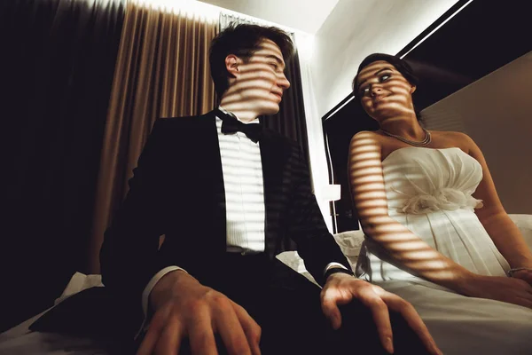 Les lumières du jour couvrent les visages des jeunes mariés pendant qu'ils sont assis sur le lit en une heure — Photo